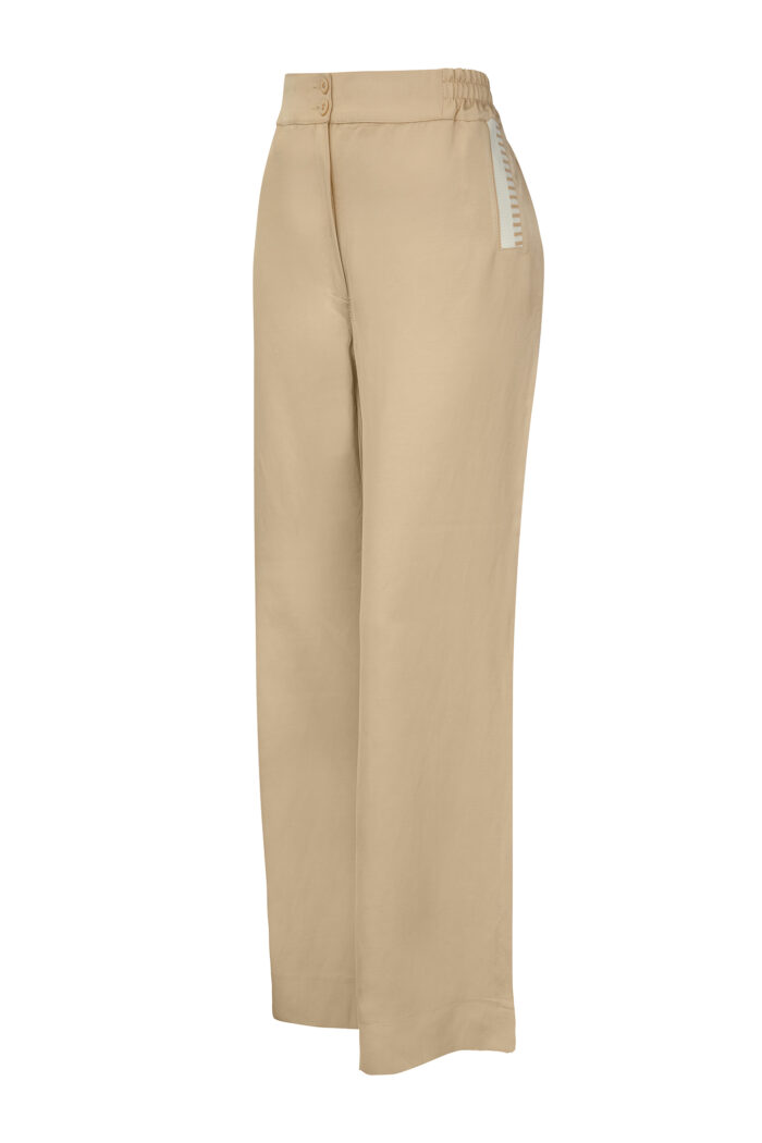 Beżowe lniane spodnie z szerokimi nogawkami i ozdobnym ściągaczem.