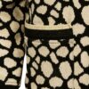 Zbliżenie na Dzianinowy sweter damski w serek z nowoczesnym wzorem w cętki i nakładanymi kieszeniami marki Jumitex.